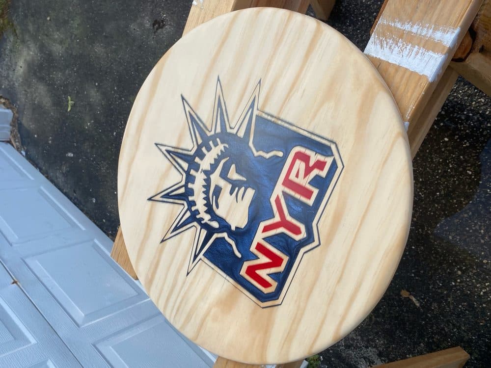 Carved NY Rangers Statue of Liberty logo on a round wood plaque