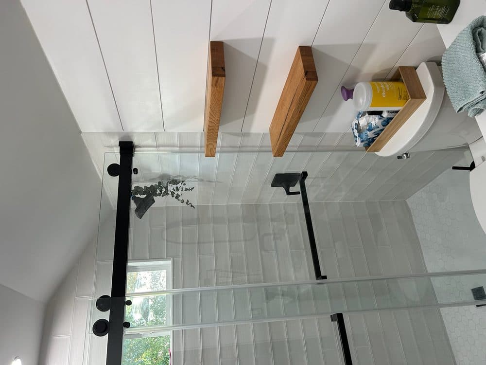 Custom bathroom remodel with floating oak shelves and shiplap wall