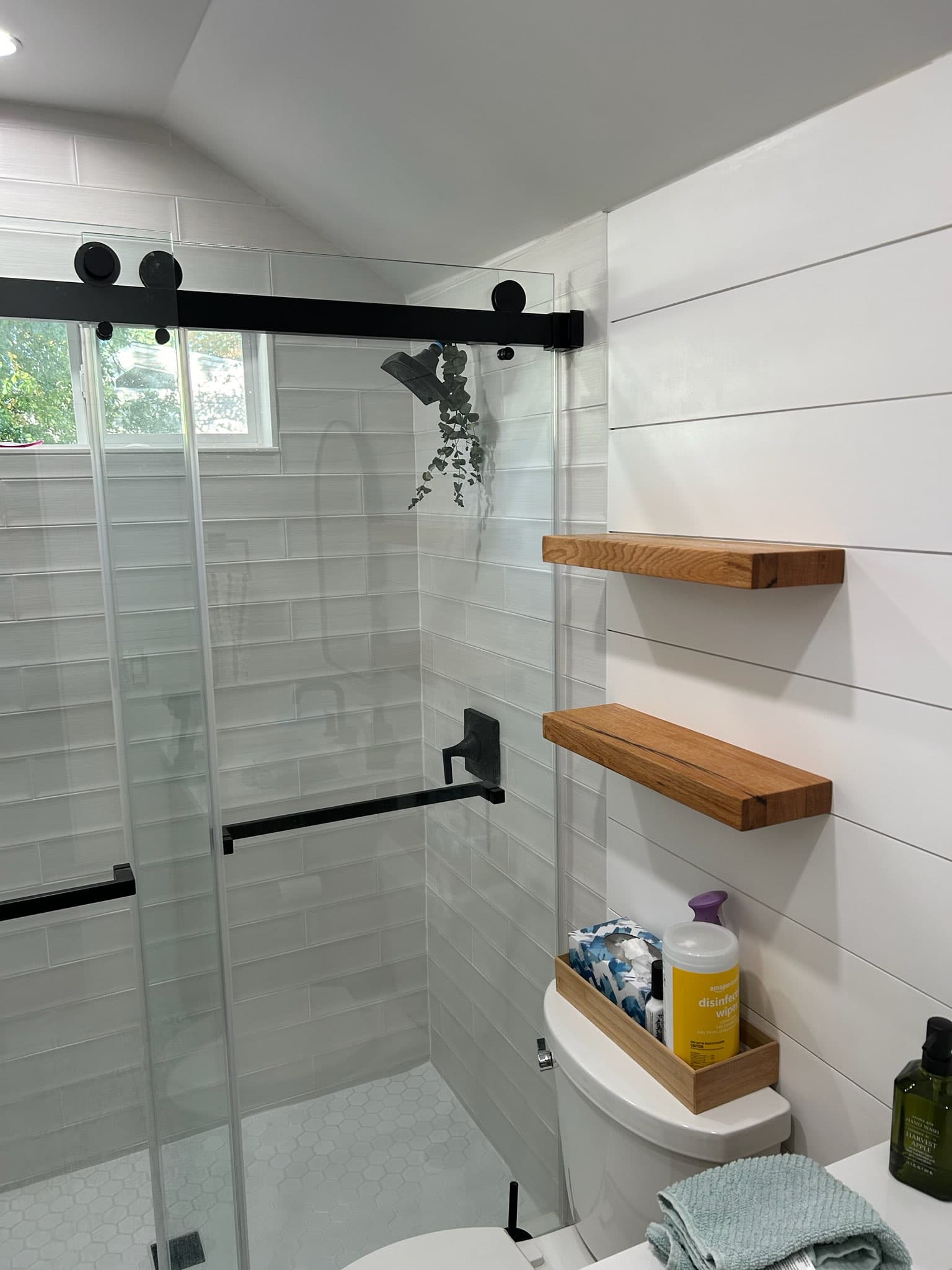 Custom bathroom remodel with floating oak shelves and shiplap wall