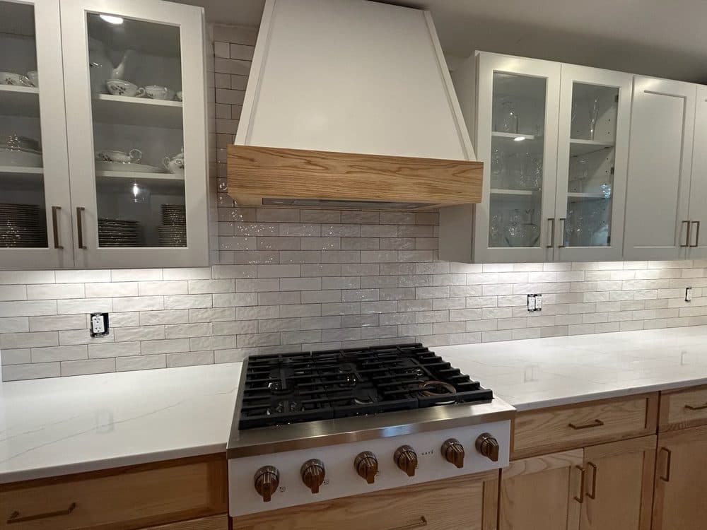 Custom kitchen range hood with oak wood accent trim