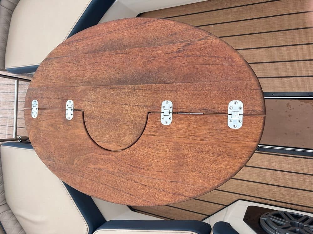 Custom round folding teak table designed for boat use