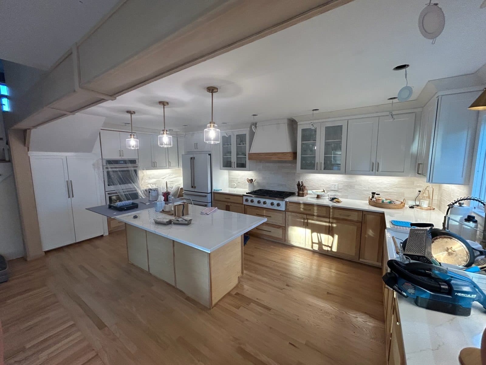 Custom two-tone kitchen cabinetry with center island and wood accents