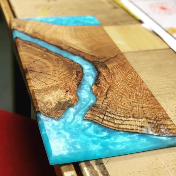 Live edge oak board with turquoise epoxy resin river running through center