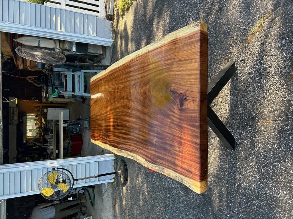 Live edge walnut dining table with black metal base in a modern dining room