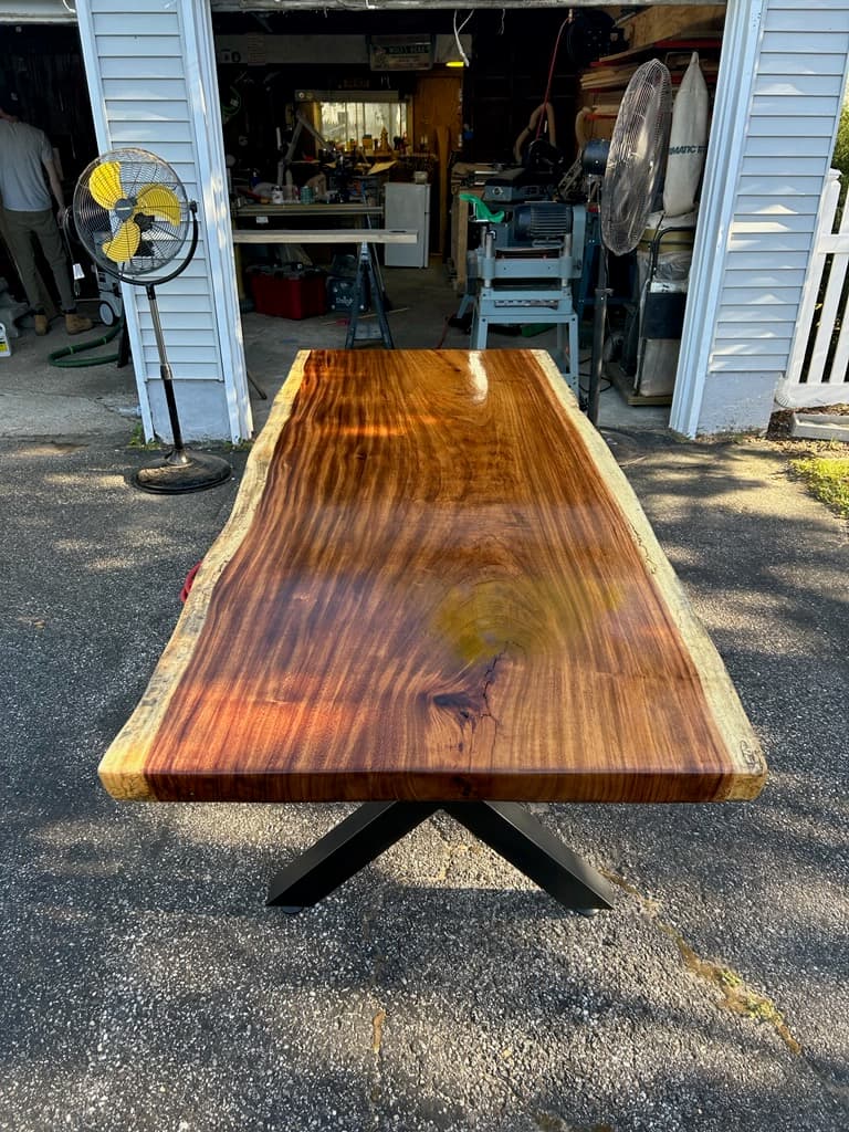 Live edge walnut dining table with black metal base in a modern dining room