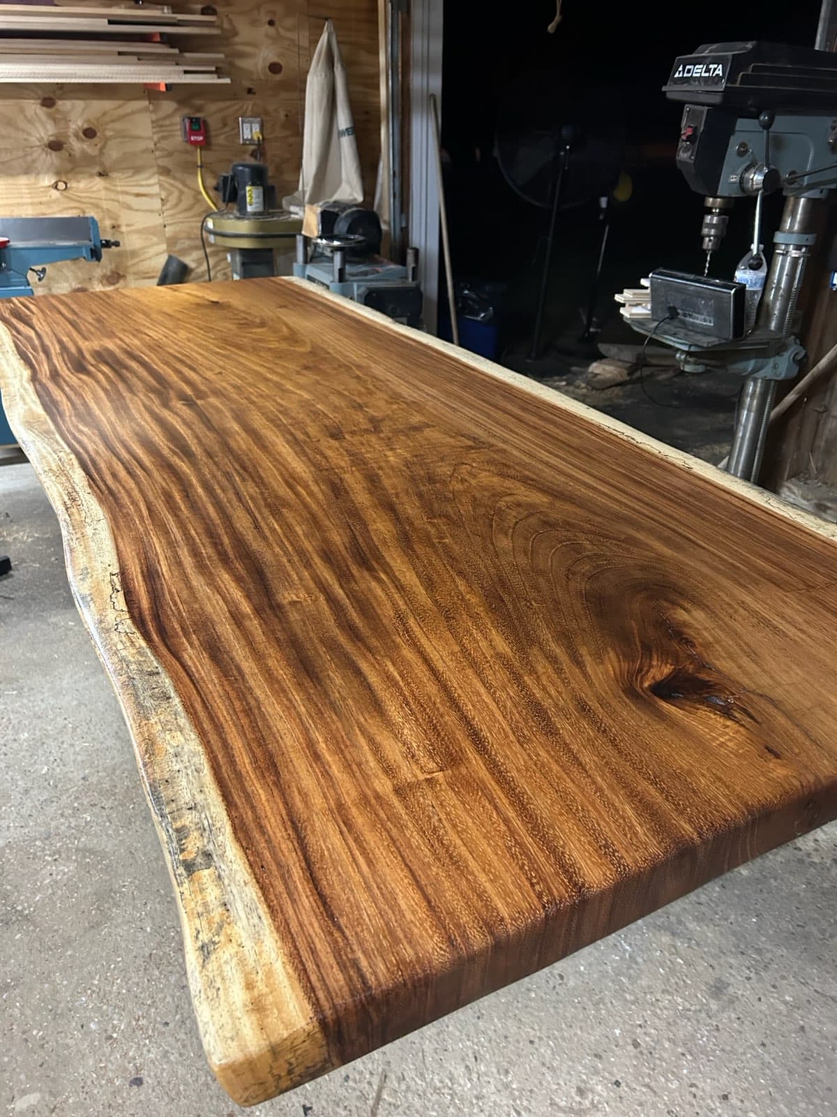 Finished live edge walnut slab with smooth sanded surface and natural bark edge