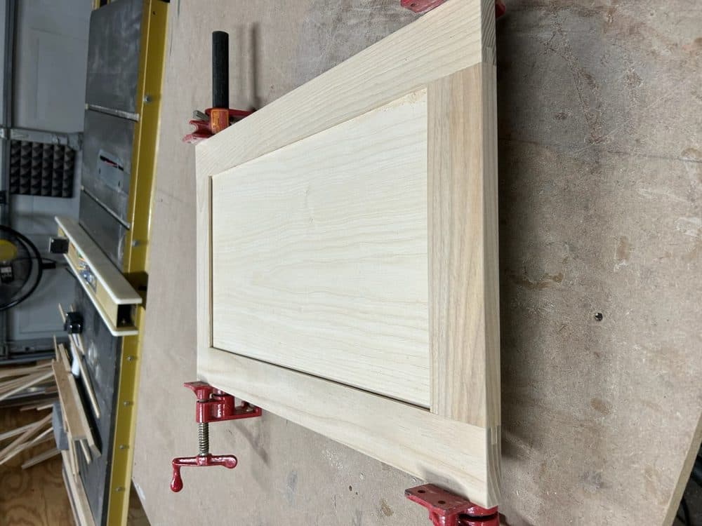 Maple shaker style raised panel cabinet door in workshop