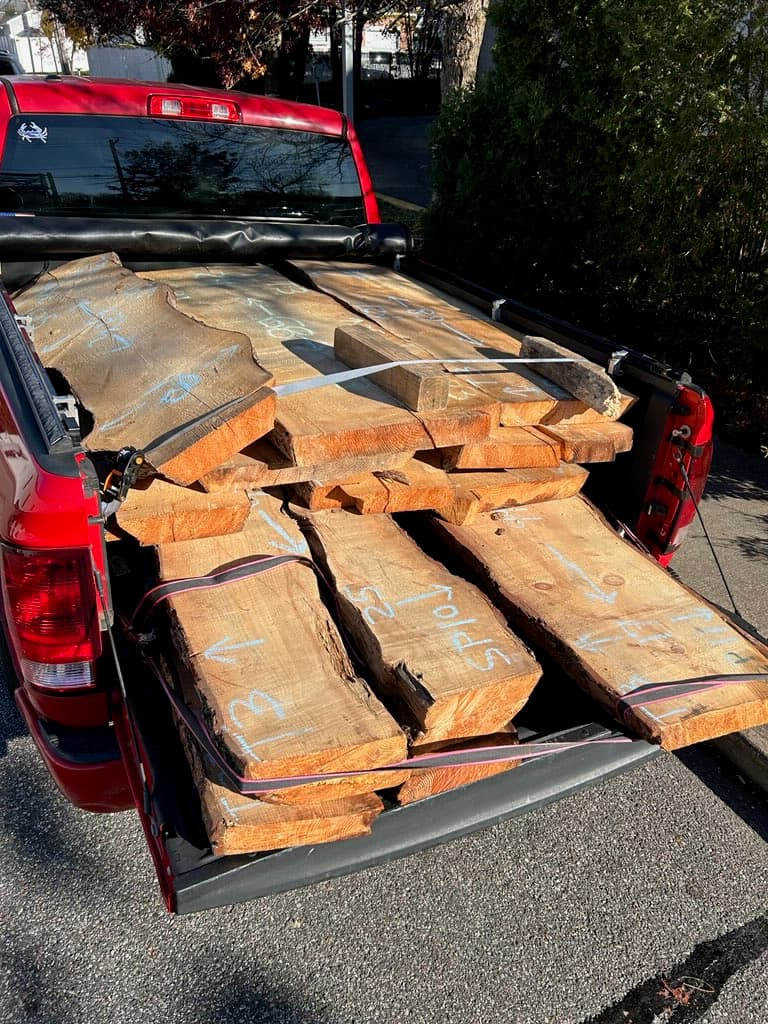 Raw live edge wood slabs being delivered on a truck