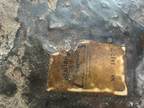 Close-up of vintage burl table manufacturer label showing craftsmanship heritage