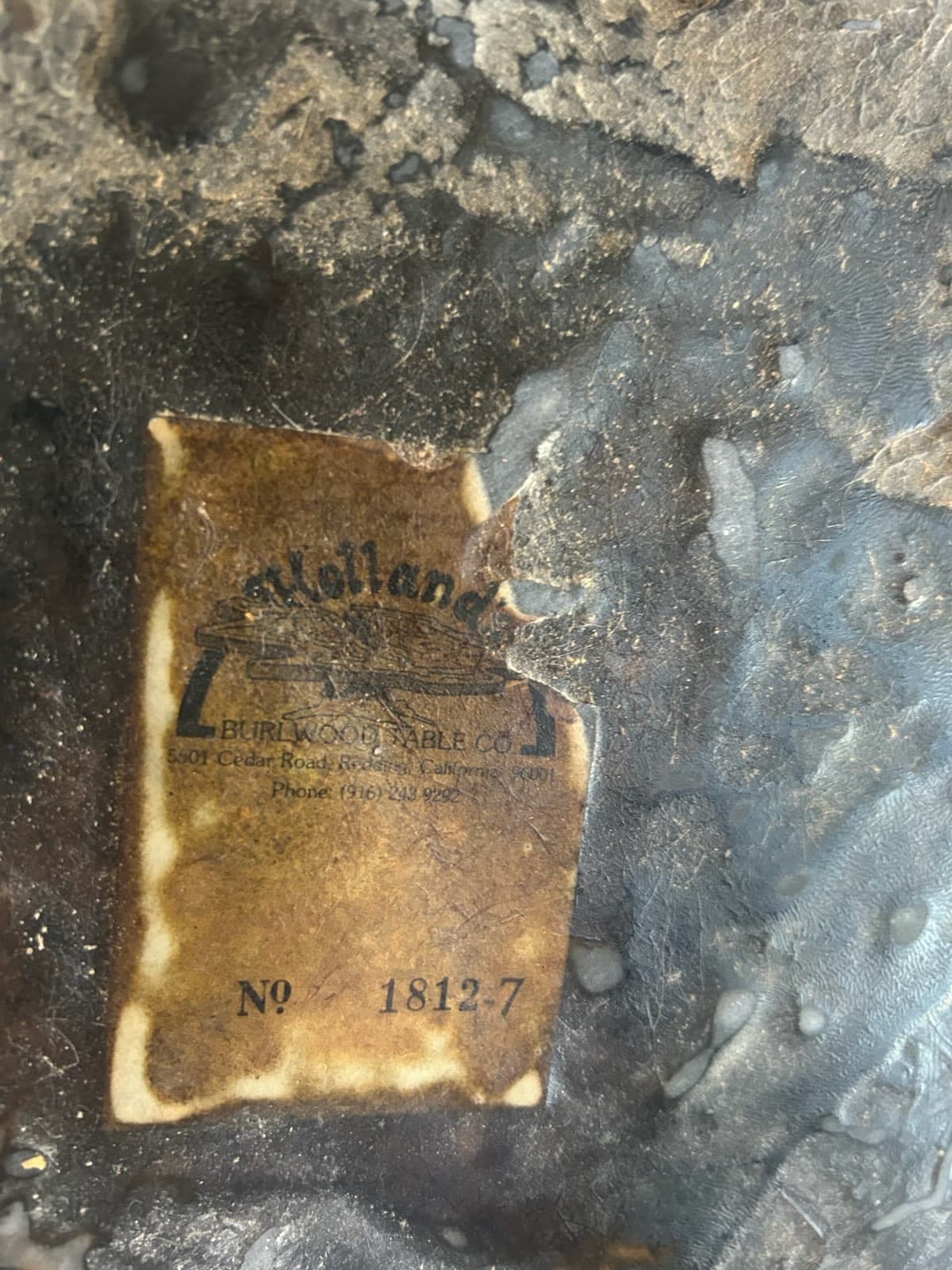 Close-up of vintage burl table manufacturer label showing craftsmanship heritage